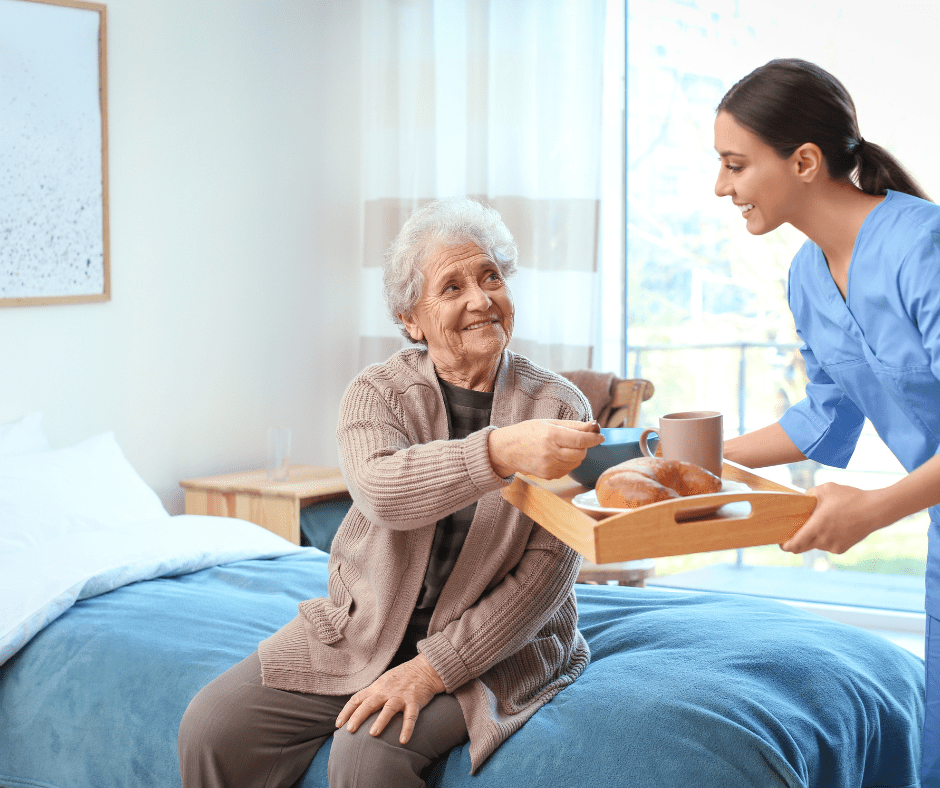 A woman handing food to an elderly person.